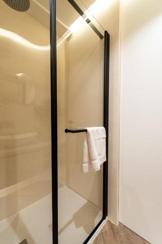 a glass shower door in a bathroom with a towel at Rooms & Apartment Laura in Split