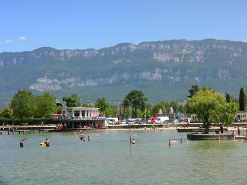 un groupe de personnes dans l'eau sur une plage dans l'établissement Residence de la Plage, au Bourget-du-Lac