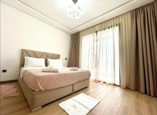 TamarisにあるBeachfront luxury apartmentのベッドと大きな窓のある寝室