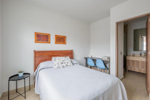 a bedroom with a bed and two blue chairs at Olivia's home in Zibata Queretaro in La Cañada