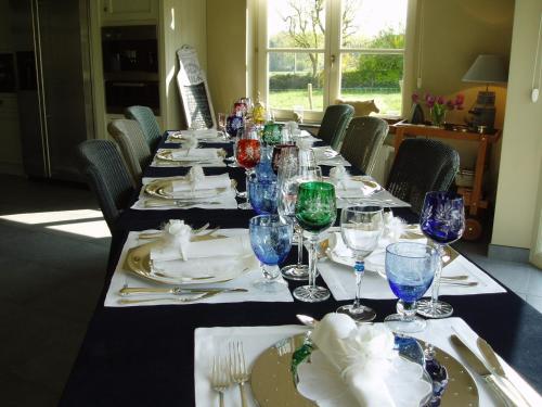 a long table with plates and wine glasses on it at B&B Vallis Dyliae in Korbeek-Dijle