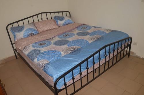 ein Bett mit einer blauen Decke und Kissen darauf in der Unterkunft Torobali IMMO Studio 7- Modern & Bright- Central Bamako - WIFI & Solar Power in Bamako