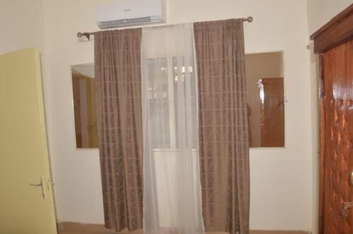 ein Fenster mit Vorhängen in einem Zimmer in der Unterkunft Torobali IMMO Studio 7- Modern & Bright- Central Bamako - WIFI & Solar Power in Bamako