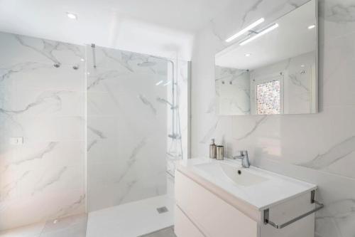 a white bathroom with a sink and a shower at Aparamento Afirama in Candelaria