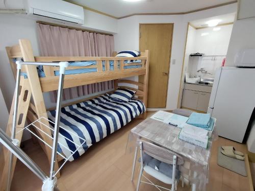 a small room with a bunk bed and a table at Guesthouse Mulberry Kagoshima- Vacation STAY 50746v in Kagoshima