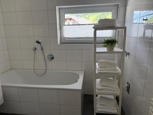 a white bathroom with a tub and a window at Bestezeit Appartements in Schladming