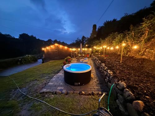 a hot tub in a garden at night with lights at Beechtree Chalet in Warrenpoint