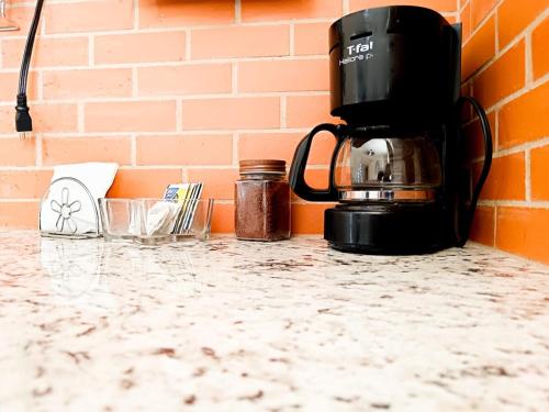 a coffee maker on a counter next to a brick wall at Estancia luxury central, Paseo Durango in Durango