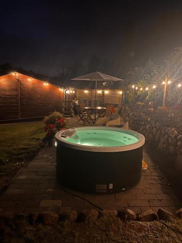 a hot tub in a yard at night at Beechtree Chalet in Warrenpoint