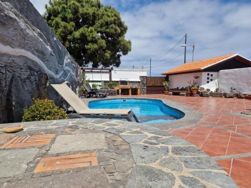 a swimming pool with a bench next to a house at La Chosita in Icod de los Vinos