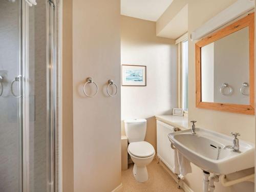 a white bathroom with a toilet and a sink at 4 bed in Mindrum 86272 in Carham