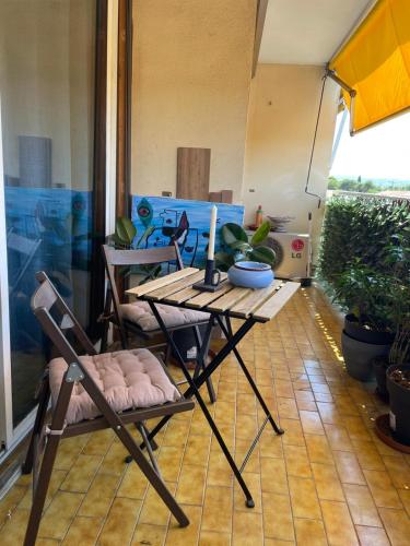 a table and chairs on a patio with a candle at Cocon du Jaï in Marignane