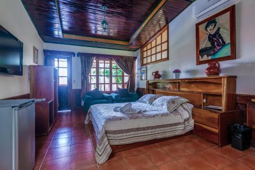 a bedroom with a bed and a tv in a room at Hotel Mar de Luz in Jacó