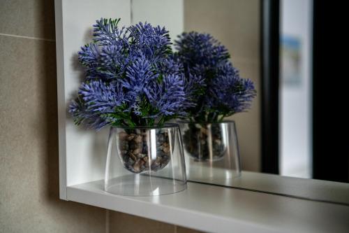 two vases with blue flowers sitting on a shelf at Most - Bitka za ranjenike na Neretvi in Jablanica