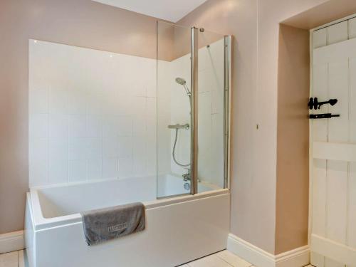 a bath tub with a glass shower in a bathroom at 3 Bed in Bamford PK838 in Bamford