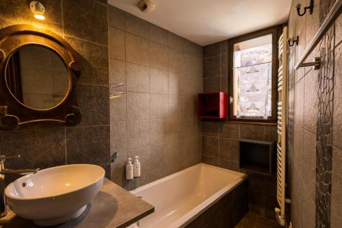 a bathroom with a tub and a sink and a mirror at Résidence Les Etoiles Des Neiges - 4 pièces 8/9 personnes exposé Sud MAE-9534 in Valloire