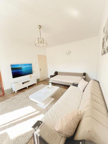 a living room with a couch and a tv at Home NP Apartments in Novi Pazar