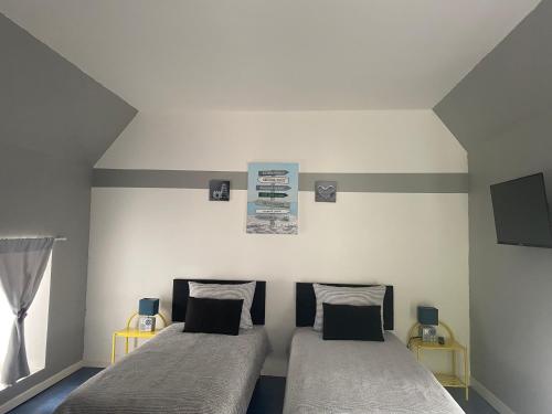 une chambre avec deux lits et une fenêtre dans l'établissement Studio à Vierville-sur- mer(plage du Débarquement), à Vierville-sur-Mer