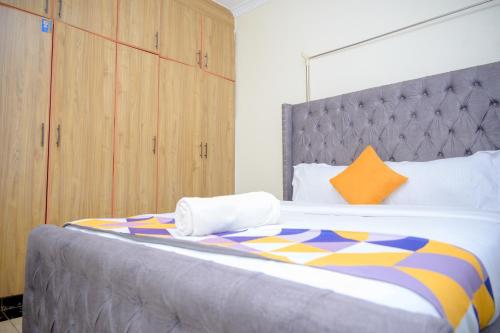 a bedroom with a large bed with an orange pillow at SpringStone executive apartment A 11 in Ongata Rongai 