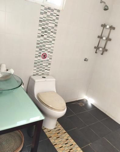a small bathroom with a toilet and a table at Family Villa in Las Galeras, Samaná in Las Galeras