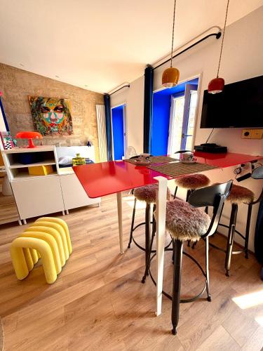 une salle à manger avec une table et des chaises rouges dans l'établissement Pop'appart, à Bordeaux