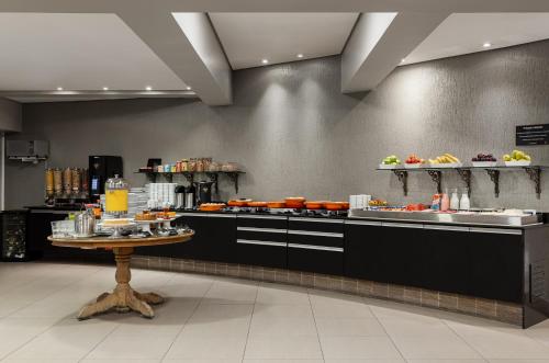 a buffet line in a restaurant with a table at Araçatuba Plaza Hotel in Araçatuba
