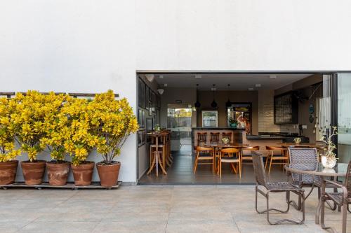 a patio with tables and chairs and yellow flowers at Araçatuba Plaza Hotel in Araçatuba