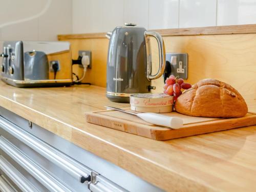 a loaf of bread on a cutting board on a counter at 3 Bed in Nailsworth 78968 in Nailsworth
