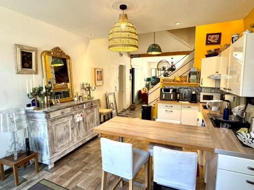 une cuisine avec une grande table en bois et des placards blancs dans l'établissement VIGNERONNE VILLAGE avec PATIO, à Maureilhan-et-Raméjan
