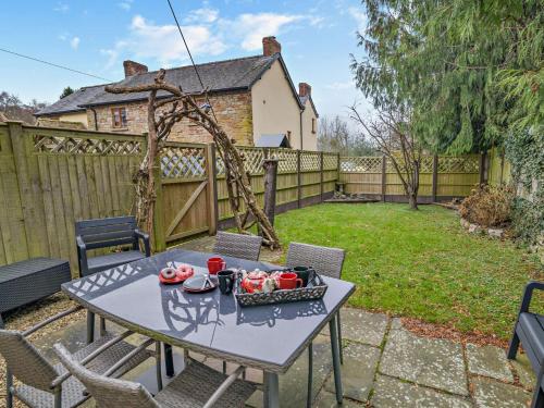 a patio with a table and chairs in a yard at 2 Bed in Coleford 78181 in Symonds Yat