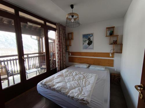 ein Schlafzimmer mit einem Bett und einem Balkon in der Unterkunft Résidence Plein Soleil - Appartement plein sud avec superbe vue, balcon, parking. MAE-9004 in Montgenèvre