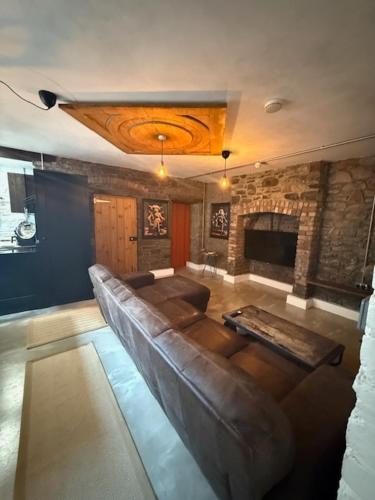 a living room with a leather couch and a fireplace at Stylish Industrial 1 Bed in Bristol