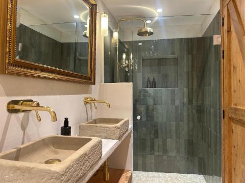 a bathroom with two sinks and a shower at Ses Terrisses Hotel in Palafrugell