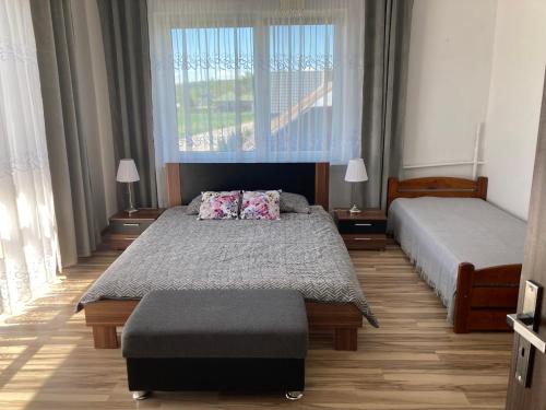 a bedroom with two beds and a window at Apartament Villa Olivia in Szczebrzeszyn
