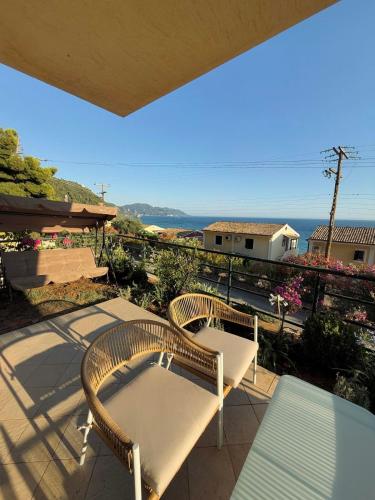 two wicker chairs and a table on a balcony at Lumiere Glyfada 1 in Glyfada