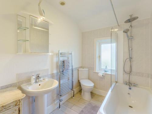 Un baño con lavabo, inodoro y ducha. en 4 Bed in Bembridge IC070, en Bembridge