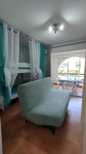 un salon avec un canapé vert et une fenêtre dans l'établissement Appartamento climatizzato di 42 mq a Marina di Bravone a 200m dalla spiaggia, à Linguizzetta