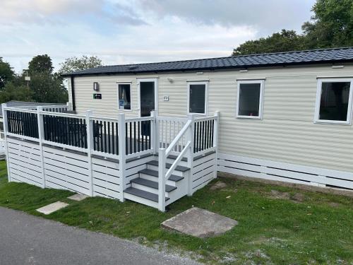 a white mobile home with a white railing at HoneyBees At Glade 17 in Bucks Mills