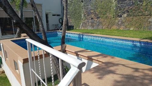 a swimming pool with a white rail next to a house at New house with pool, excellent, 3 bedrooms in Pazulco