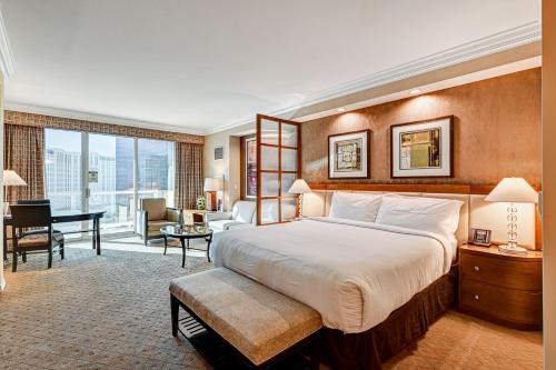a hotel room with a large bed and a desk at Sierra Studio at MGM Signature Tower 1 with Balcony Strip View 5 MIN WALK FROM F1 GRANDSTAND in Las Vegas