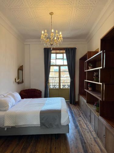 a bedroom with a bed and a chandelier at Casa Vega in Cuenca