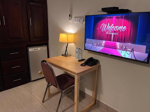 a room with a desk with a television on a wall at Lakepoint Villa in Entebbe