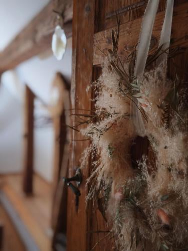 a wreath is hanging on a wooden wall at Exklusives Naturjuwel - Kühbartl Simmerl in Oberhaag