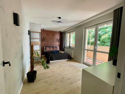 a living room with a bed and a large window at Stylish apartment by the castle in Malbork