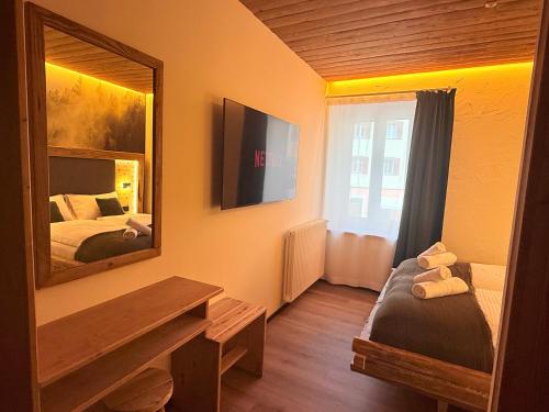 a room with a mirror and a bed in it at Il bosco di Fiemme in Predazzo