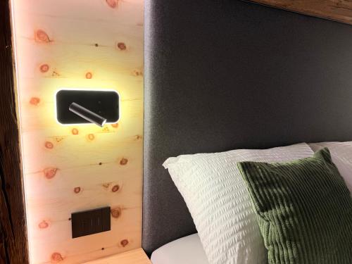 a room with a bed with a wall with a switch at Il bosco di Fiemme in Predazzo