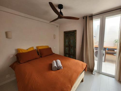 une chambre avec un lit avec un ventilateur de plafond dans l'établissement La Casa Rosie, charme paisible à Palavas les Flots, à Palavas-les-Flots