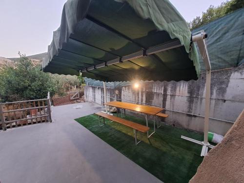 a patio with a wooden table under a canopy at La Casa di Argia in Bugnara