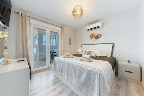a bedroom with a bed and a large window at SUNNY SWEET HOME OLGA in Torrevieja