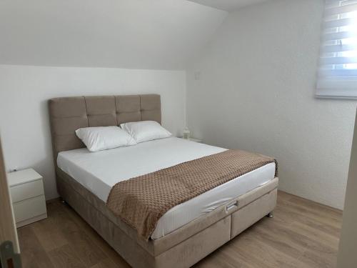 a bedroom with a large bed with white sheets at Daily corner in Bujanovac